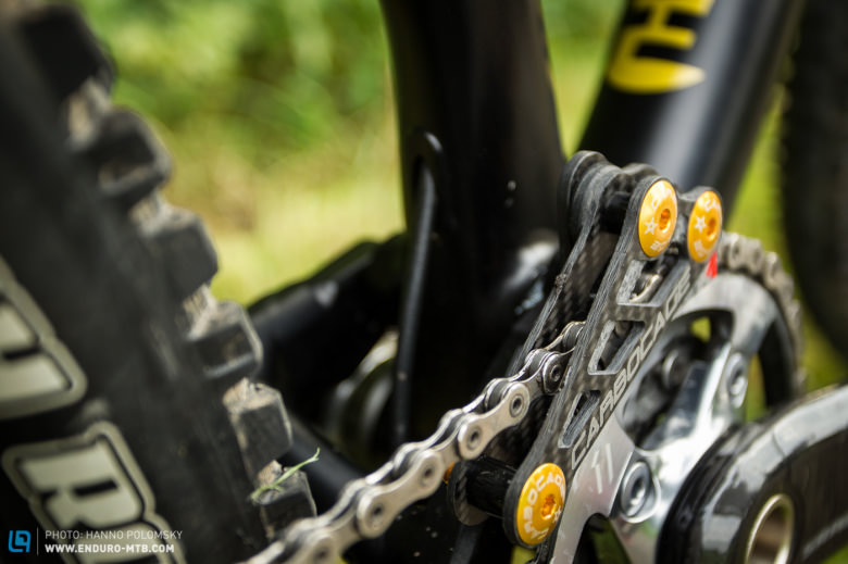 The chain is held in place by a Carbocage X1 chain guide that now features anodized gold bolts!