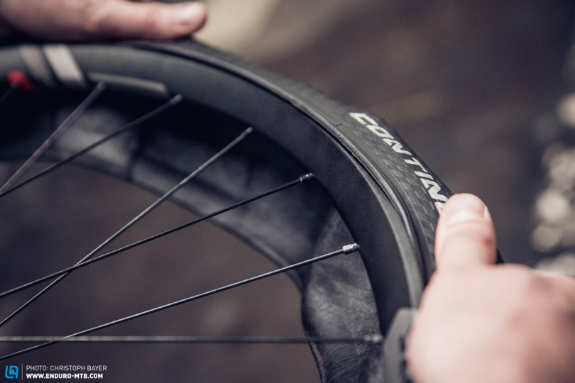 The whole tire needs to be lying comfortably in the rim bed. Tip: Pros align the logos with the valve hole.